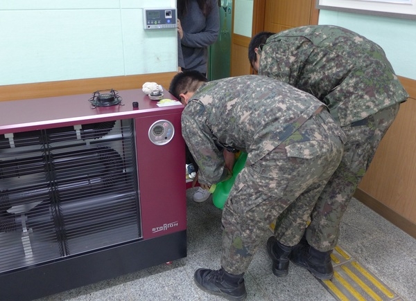 현관 난로의 연료 주입에 발벗고 나선 장병들 